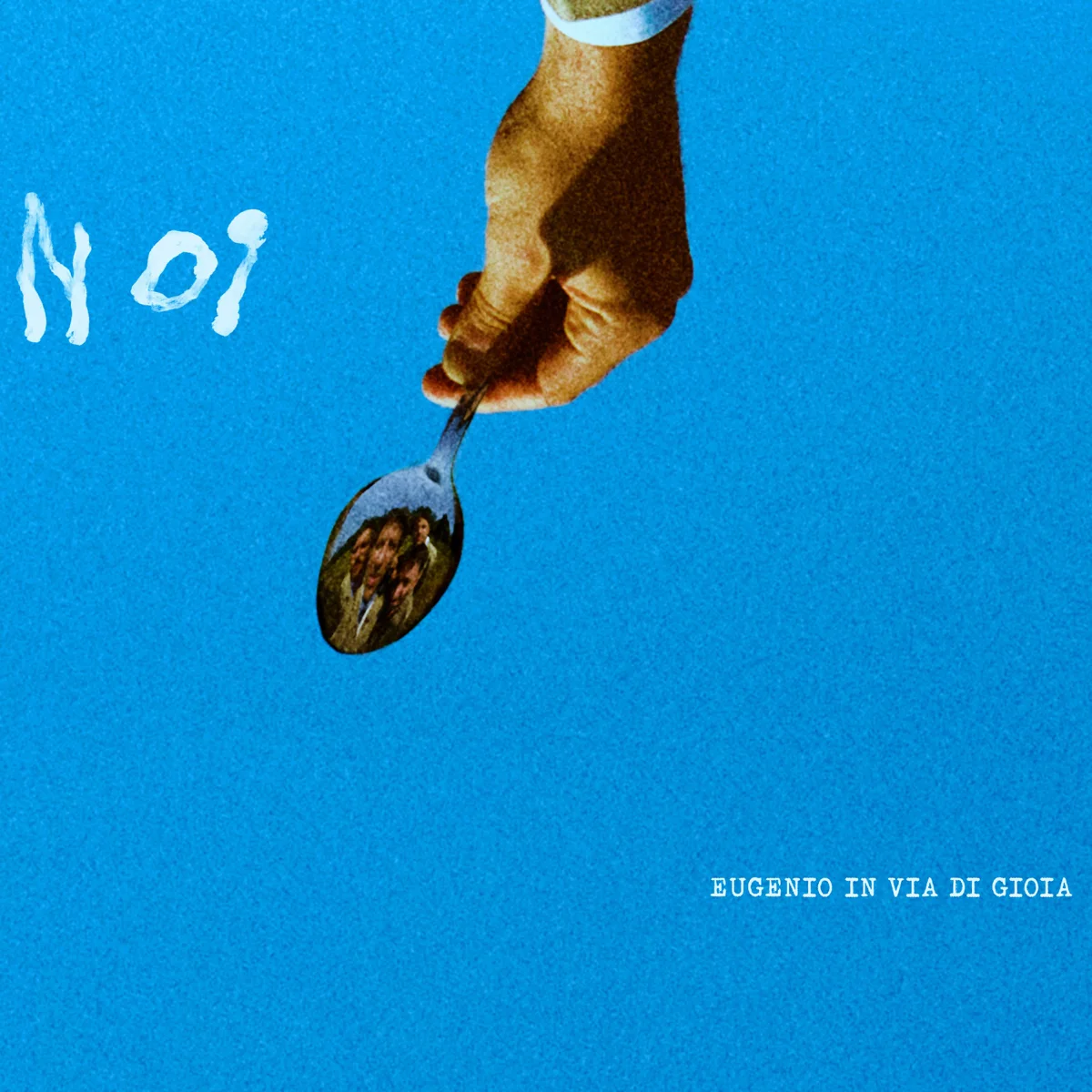 Copertina di N OI: una mano tiene un cucchiaio in cui si riflette la band